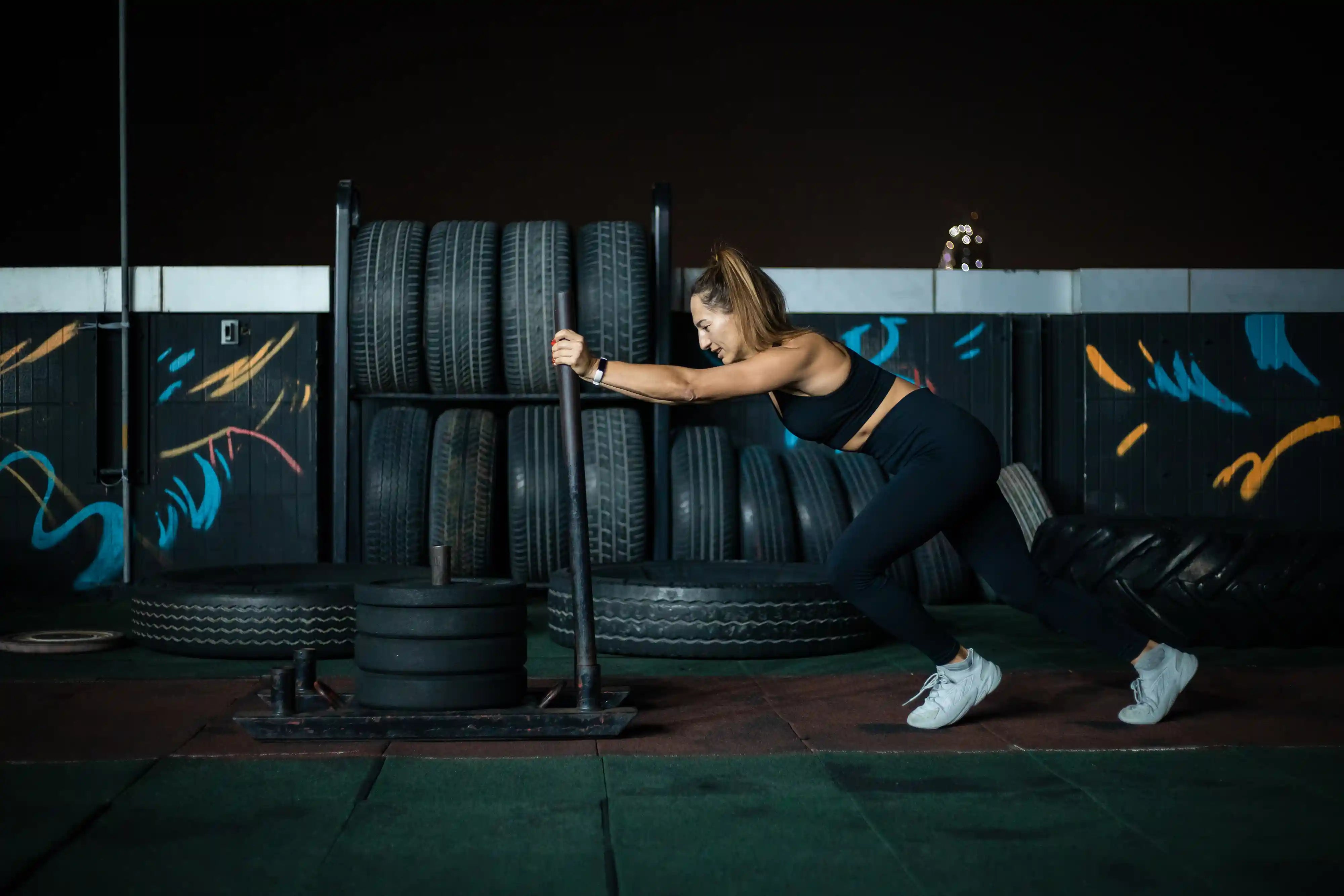 woman pushing sled in a gym